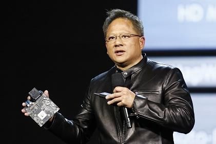 Nvidia CEO Jen-Hsun Huang holds the company's super computing automotive module featuring its new Xavier chip at his CES keynote